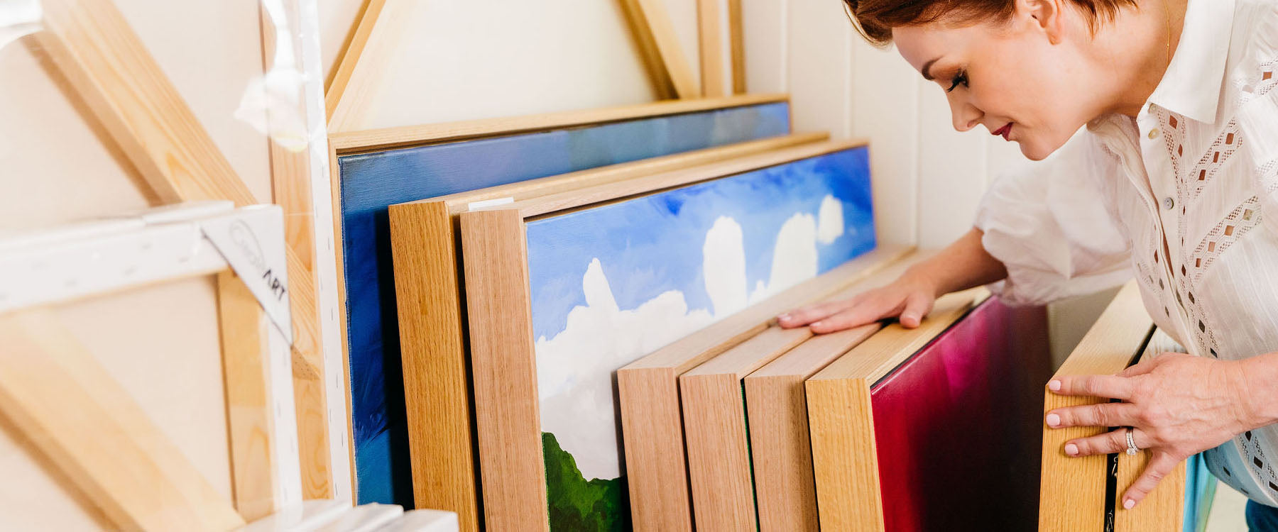 Madeleine looking through framed artwork - Madeleine McKinlay Art